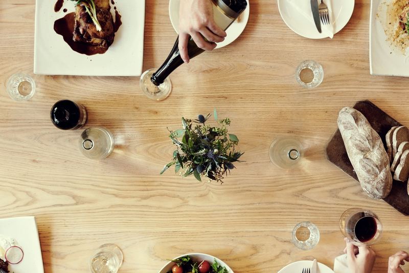 Friends sharing a meal at a wooden table